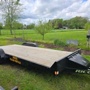 Black flatbed car trailer on grassy field