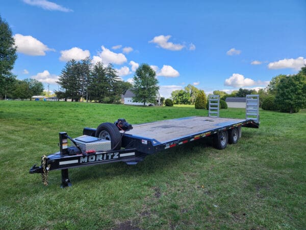A large trailer is parked in the grass.