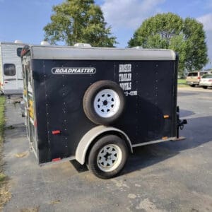 A black trailer with two tires on it