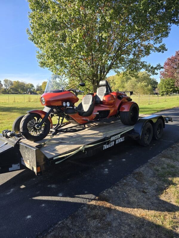 A red motorcycle is on the trailer.