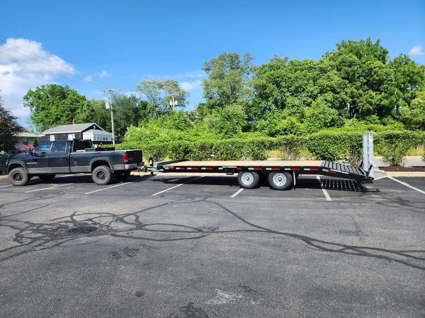 A truck is pulling a trailer in the parking lot.